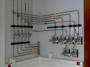 Exemple d'installation de tuyaux de gaz muraux en intérieur dans un coin de pièce réalisé par Mitéa